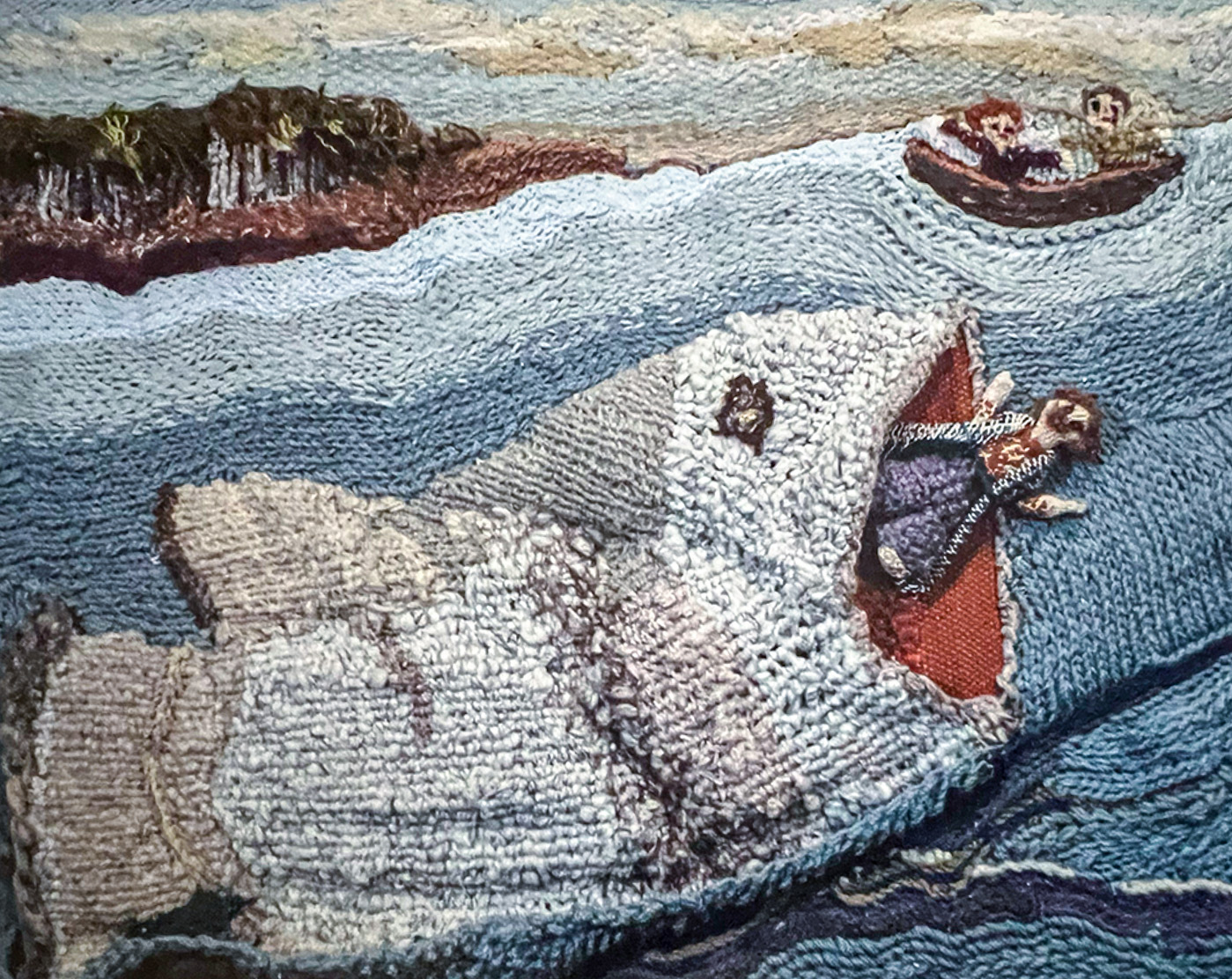 Fiber art depicting Jonah inside the whale with a small boat nearby.