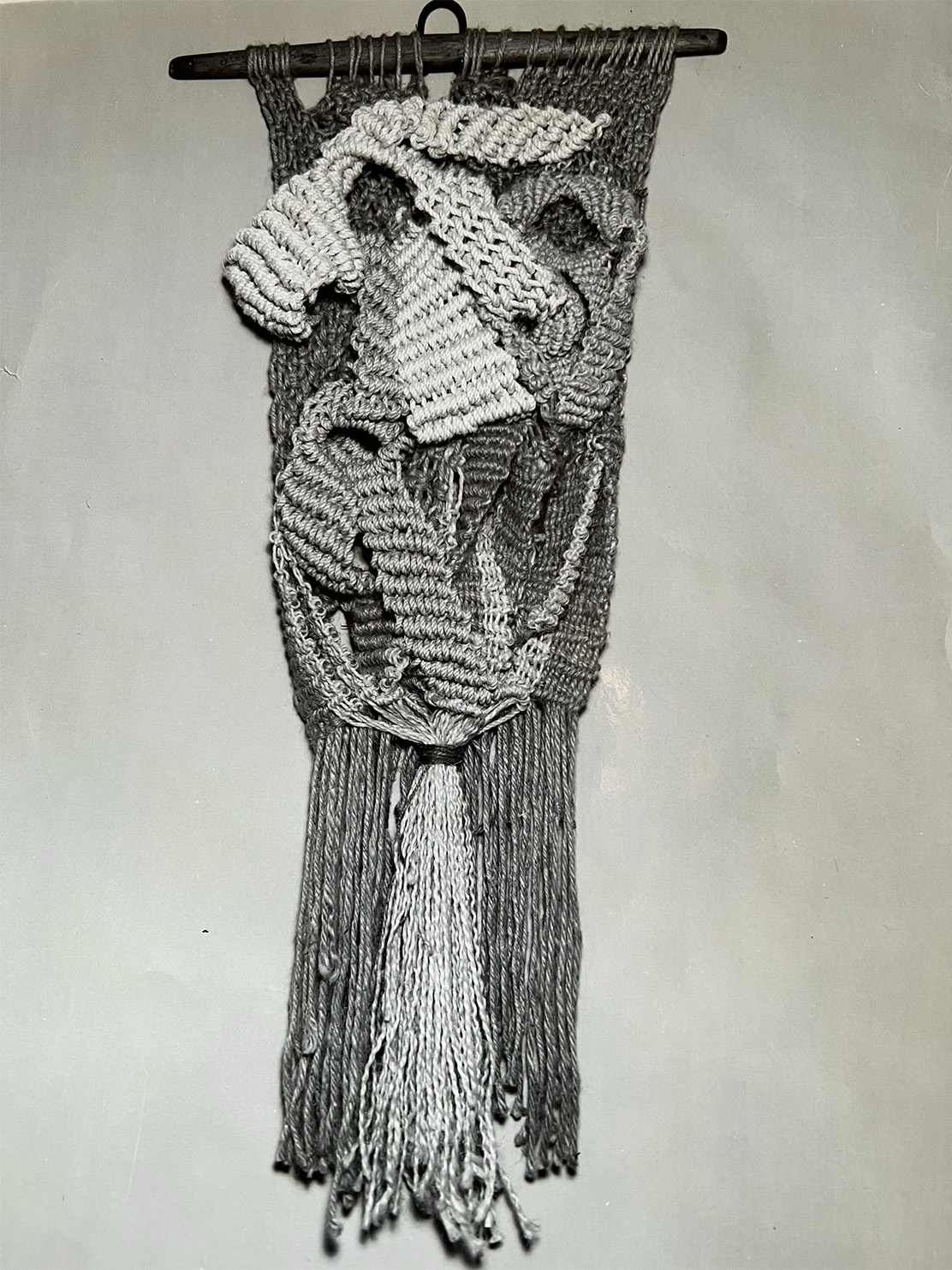 A hanging loom-woven bag with long cascading tassels.