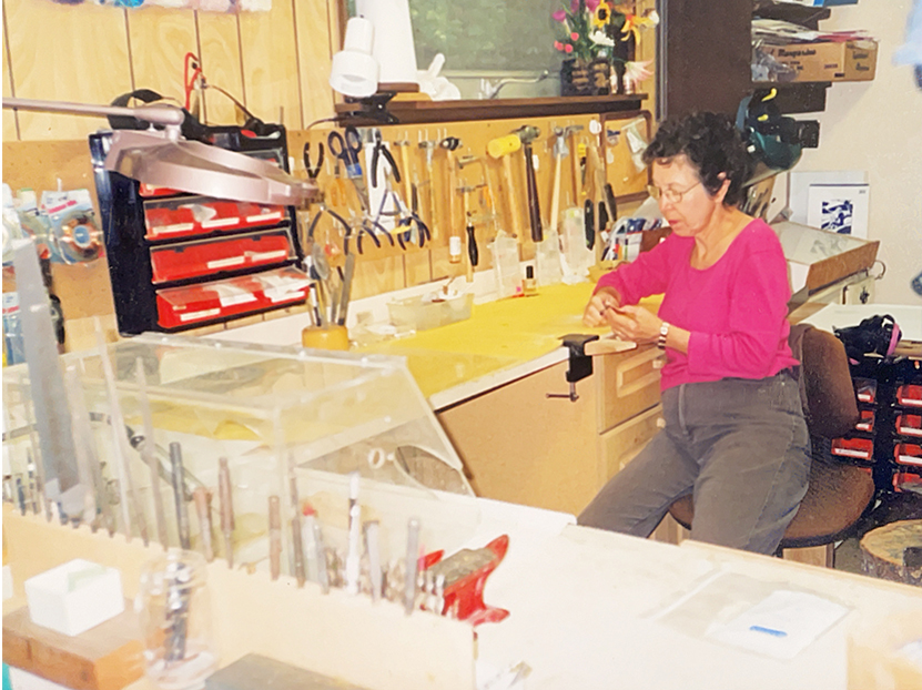 Joanne at her jewelry bench, tools and files arrayed in front of her.